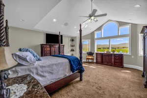 Carpeted bedroom with vaulted ceiling and ceiling fan