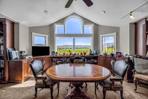 Dining area featuring light carpet, ceiling fan, lofted ceiling, and a textured ceiling