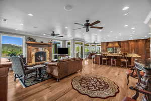 Living room featuring crown molding, plenty of natural light, sink, and light wood-type flooring