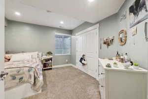 Bedroom featuring light carpet