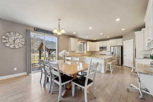 Dining area featuring light hardwood / wood-style flooring and a notable chandelier