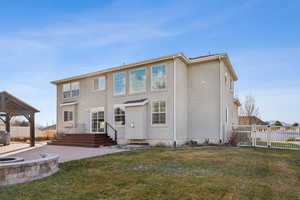 Rear view of house with a patio, a yard, and an outdoor fire pit