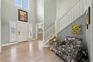 Foyer entrance with a towering ceiling and light hardwood / wood-style floors