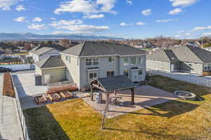 Back of house featuring an outdoor fire pit, a yard, a mountain view, and a patio area