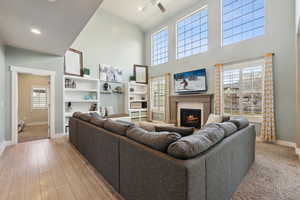 Living room featuring ceiling fan, light hardwood / wood-style flooring, and a high ceiling