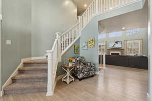 Stairway featuring wood-type flooring and a high ceiling