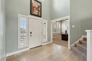 Entryway featuring a high ceiling, ceiling fan, and light wood-type flooring