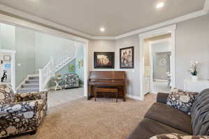 Living room with light colored carpet and ornamental molding