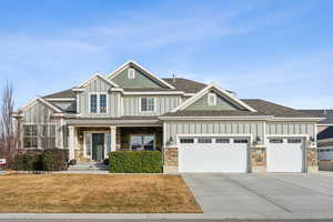 Craftsman-style home featuring a garage and a front lawn