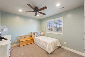 Carpeted bedroom featuring ceiling fan