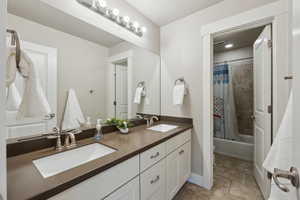 Full bathroom featuring vanity, shower / bath combination with curtain, and toilet