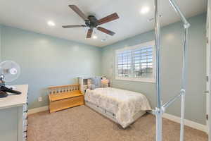 Bedroom with ceiling fan and light colored carpet