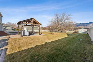 View of yard featuring a mountain view, a gazebo, a patio area, and a storage unit