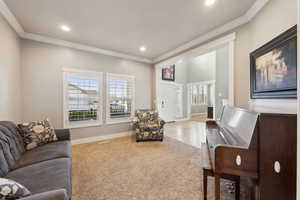 Carpeted living room with ornamental molding