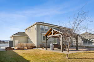 Back of house featuring a gazebo, a lawn, and a patio