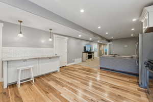 Living room with a fireplace and light hardwood / wood-style flooring