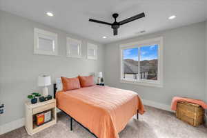 Carpeted bedroom featuring ceiling fan