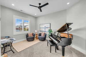 Living area with ceiling fan and carpet floors