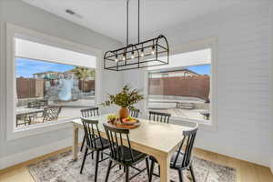 Dining space with wooden walls and light wood-type flooring