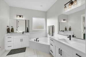 Bathroom with a relaxing tiled tub and vanity