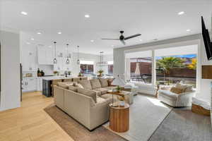 Living room featuring ceiling fan, a healthy amount of sunlight, sink, and light hardwood / wood-style floors