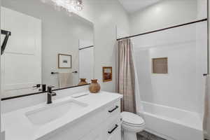 Full bathroom featuring vanity, toilet, and shower / bathtub combination with curtain