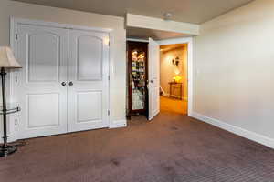 Unfurnished bedroom with a closet and dark colored carpet