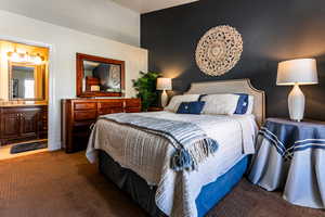 Bedroom featuring carpet floors, sink, and ensuite bath