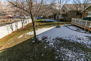 Yard covered in snow featuring a deck