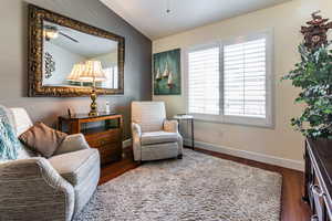 Sitting room featuring dark hardwood / wood-style flooring, lofted ceiling, and ceiling fan