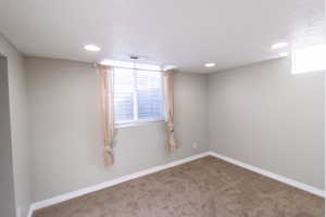 Carpeted empty room featuring a textured ceiling