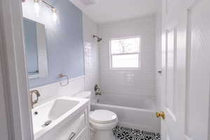 Full bathroom featuring vanity, toilet, and tiled shower / bath combo