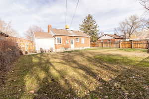 Rear view of house featuring a yard