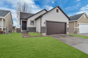 View of front of home with a garage and a front lawn