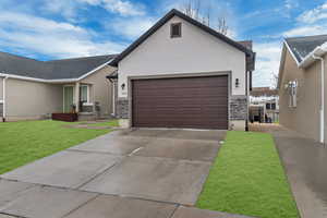 View of front of property featuring a garage and a front lawn