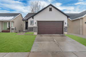 View of front of property with a garage and a front lawn