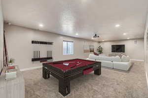 Game room featuring billiards, a textured ceiling, and carpet