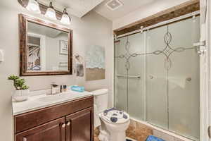 Bathroom featuring toilet, vanity, and walk in shower