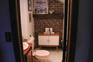 Half bathroom with charming brick wall