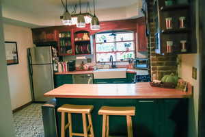 Kitchen with stainless steel appliances, butcher block counters, and a breakfast bar area