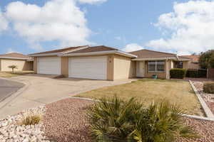 View of front of property featuring a garage and a front lawn