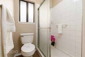 Bathroom featuring toilet and a shower with shower door