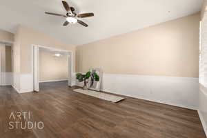 Spare room with lofted ceiling, dark wood-type flooring, and ceiling fan