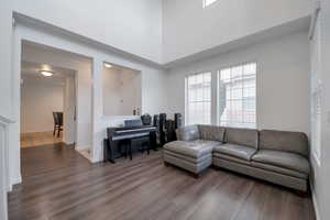 Living room featuring a towering ceiling and hardwood / wood-style floors