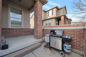 View of patio with a grill