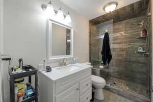 Bathroom with toilet, hardwood / wood-style floors, vanity, and a shower with shower door