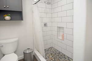 Bathroom with toilet and a shower with shower curtain