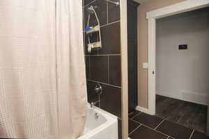 Bathroom featuring wood-type flooring and shower / tub combo with curtain