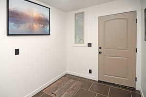 Laundry room featuring dark tile patterned flooring