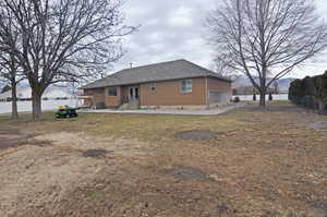 Back of property featuring a yard and central AC unit